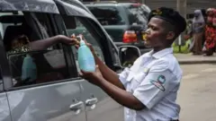 Mlinzi akimsaidia mwenyegari kujitakasa mikono