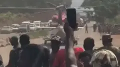 Man taking picture of a helicopter landing in a motorway
