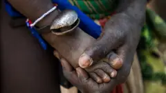 Main d'une mère de la tribu Larim touchant le pied de son bébé, dans les montagnes Boya, à Imatong, au Sud-Soudan, le 6 février 2020.