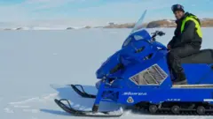 Dr Tomar riding a snow scooter.