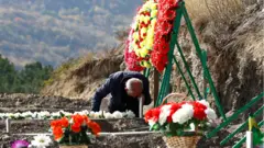 A man mourns at the grave of a fallen soldier, who was killed during the military conflict over the breakaway region of Nagorno-Karabakh, in Stepanakert 14 October, 2020.