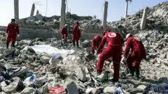 عمال الإغاثة التابعين للصليب الأحمر وسط الركام