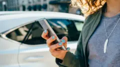 Woman using phone to summon a taxi