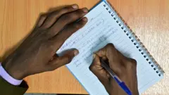 Wani likita yana rubutu da biro kan takarda
