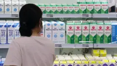 마트 우유 진열대 앞에 서있는 여자