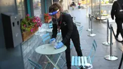 A waitress clearing a table in Liverpool