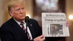 Trump holds newspaper reading, 'acquitted'