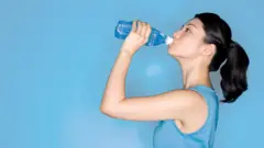 ውሃ የምትጠጣ ሴት