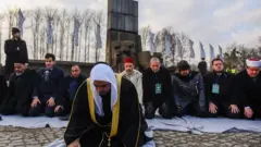 رجال دين مسلمون يصلون في أوشفيتز