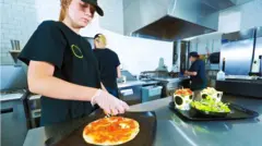 Una persona trabaja en la cocina de un restaurante de comida rápida