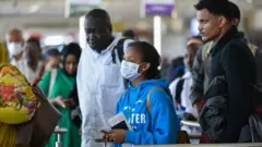One passenger wear a mask as she dey wait for Bole International Airport for Addis Ababa