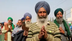 An elderly Sikh protester stands for Ardas (Sikhism worship) at Singhu border during the demonstration.Thousands of farmers from Punjab, Haryana and other states gathered for the 28th day protesting against the Government's new agricultural law, demanding to rollback these new bills.
