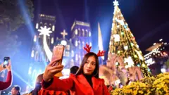 সেন্ট জোসেফ ক্যাথেড্রালের সামনে সেলফি তুলছেন এক নারী।