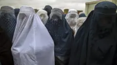 Afghan women wait to cast their ballot at a polling station in Mazar-i-sharif April 5, 2014.