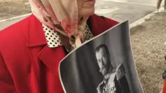 gospođa drži sliku cara Nikolaja Drugog