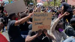 Imbere y'aho, umutambukanyi w'umukuru w'igihugu ca Namibia, Monica Kalondo, yari yashigikiye iyi myiyerekano.