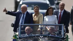 Brazil's President-elect Luiz Inacio Lula da Silva (L) waves to supporters on their way to the National Congress for their inauguration ceremony, in Brasilia, Brazil