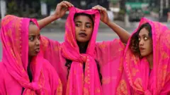 Three women dressed in traditional dresses of the Harari culture of eastern Ethiopia