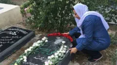 عکس کمپین حقوق بشر ایران از خانم اکملی در کنار آرامگاه فرزندش