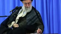 علی خامنه ای در حال نوشتن