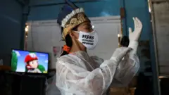 Vanderlecia memakai alat pelindung diri