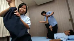ภาพในอดีตหมอนวดตาบอดยกขาของลูกค้าชูขึ้นเพื่อนวด
