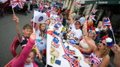 Participants wave flags during the town's street party on 3 June 2022 in Swanage, Dorset