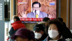 Des gens regardent la télévision qui diffuse un reportage sur une conférence de presse tenue par Lee Man-hee, fondateur de l'église Shincheonji de Jésus le Temple du Tabernacle du Témoignage, à Séoul, Corée du Sud, le 2 mars 2020