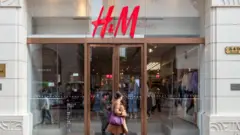 Woman walks by H&M store in Shanghai