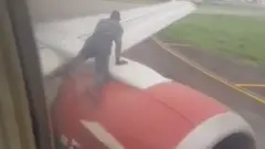 uçağa tırmanmaya çalışan kişi