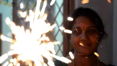 ફાટકડા ફોડી રહેલાં મહિલા