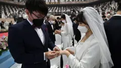 Couples exchange rings a mass wedding ceremony organised by the Unification Church in Gapyeong