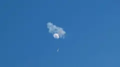 The suspected Chinese spy balloon drifts to the ocean after being shot down off the coast in Surfside Beach, South Carolina