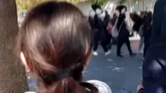 Screengrab of video posted on social media showing schoolgirls marching along a street in Gohardasht, Karaj, Iran, while waving their headscarves in the air and chanting "death to the dictator" (3 October 2022)