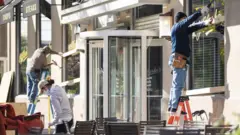 Workers board up windows at a Washington restaurant ahead of election day