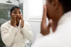 Femme qui applique de la crème sur son visage