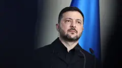 Prezydent Ukrainy Wołodymyr Zełenski na tle niebieskiej flagi