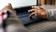 Crian;a digitando no computador