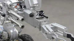 A bomb disposal robot extends its arm