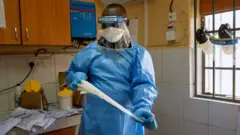 Un technicien de laboratoire enlève ses gants pour tester des échantillons de COVID-19 dans un laboratoire à Juba, au Sud Soudan, le 6 avril 2020.