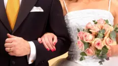 Bride linking arms with groom