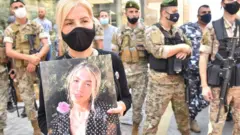 امرأة تحمل صورة ضحية جراء انفجار ميناء بيروت (صورة أرشيفية)