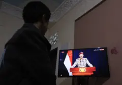 شاب يمني يشاهد خطاب المتحدث العسكري باسم الحوثي