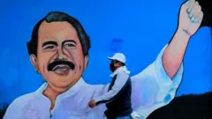 Un homme passe devant une fresque représentant le président nicaraguayen Daniel Ortega, à Managua.