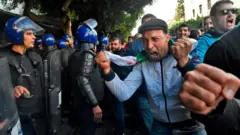 Des manifestants face aux forces de police en Algérie le jour du vote