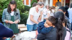 Una mujer con un niño en sus brazos, parte de los migrantes enviados a Martha's Vineyard.