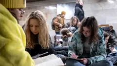 School students attend a lesson as they take shelter inside a metro station during massive Russian missile attacks in Kyiv, Ukraine, on 10 February 2023