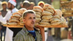 An Egyptian man sells bread outside the al-Azhar mosque in Cairo on December 8, 2017
