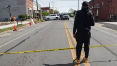 DJ Keenan Cooper looks at the scene following a shooting that took place Saturday night at the Mahogany Masterpiece dance studio in Dadeville, Alabama