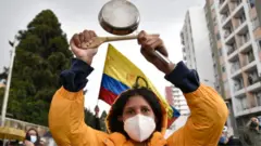 A demonstrator makes noise banging a pot during a protest against the government of President Ivan Duque on 4 May